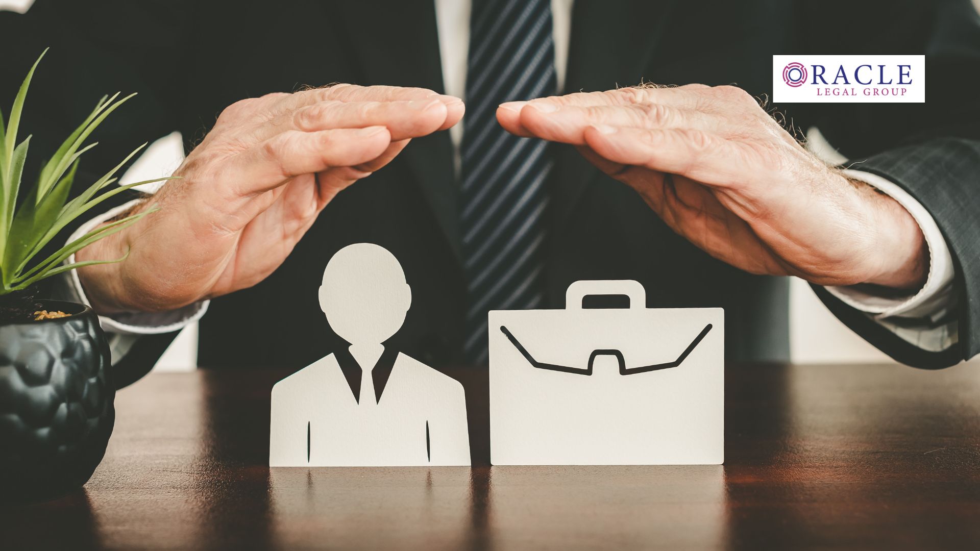 Businessperson’s hands held protectively over paper cutouts of a professional figure and a briefcase, symbolizing safeguarding business assets and relationships; Oracle Legal Group logo in the corner