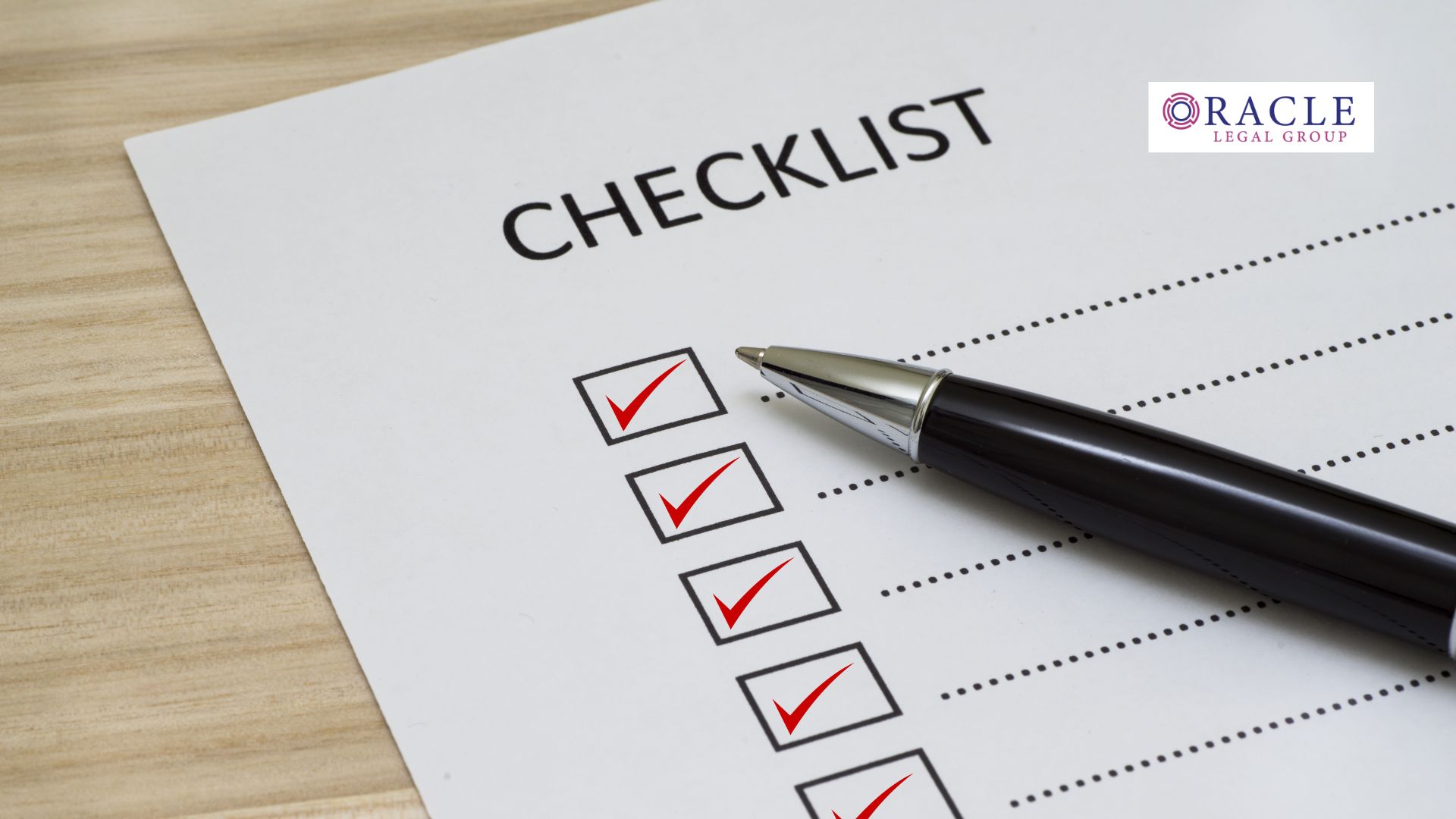 Close-up of a checklist with red checkmarks and a black pen on a wooden surface; Oracle Legal Group logo in the corner, symbolizing preparedness and legal compliance in business operations